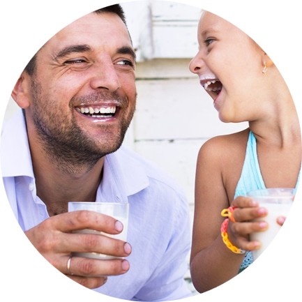 Father and daughter laughing and drinking milk