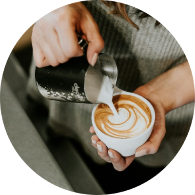 Barista pouring milk into mug
