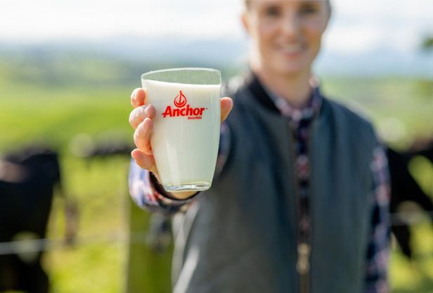 Woman holding a glass of Anchor milk